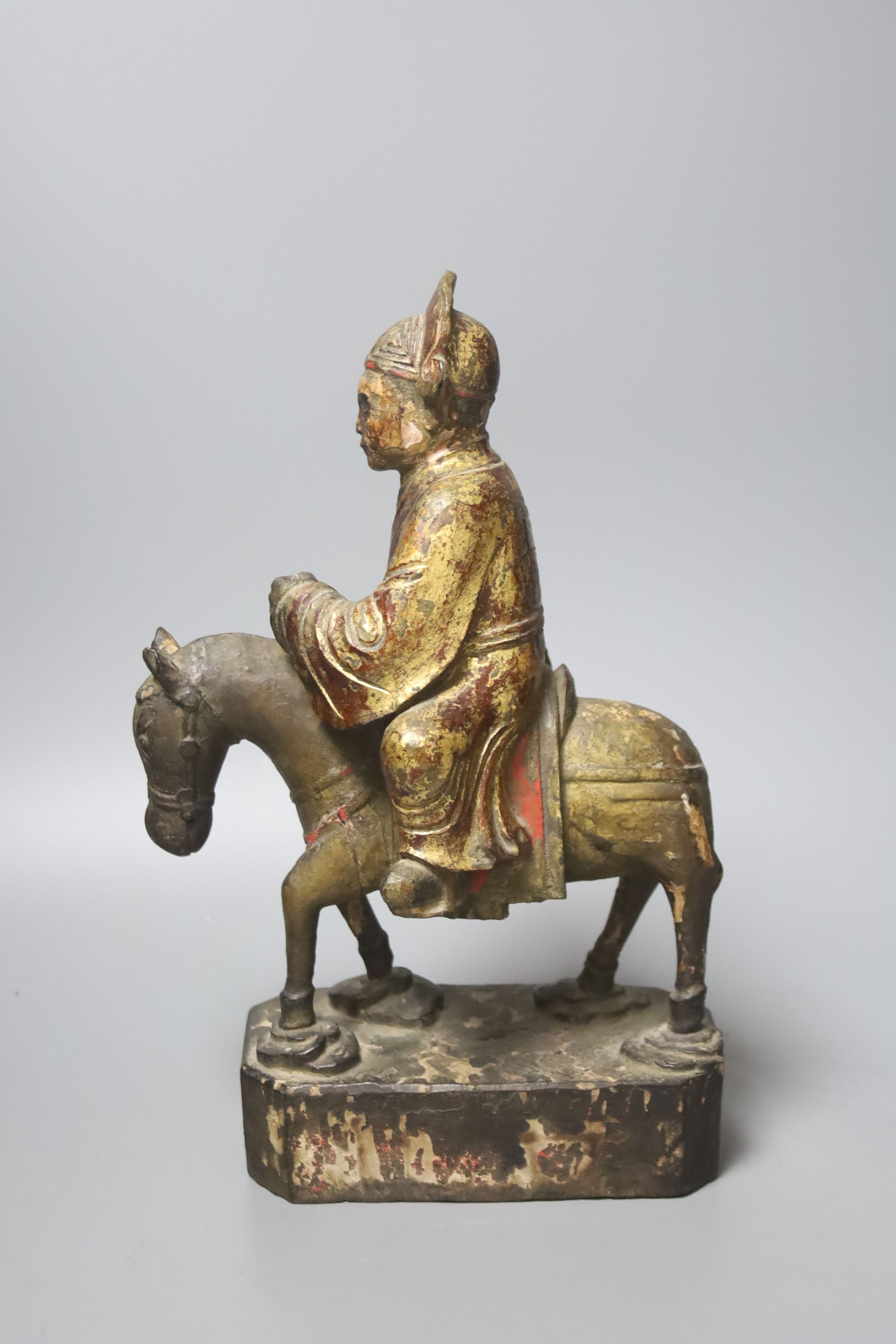 An 18th/19th century Chinese lacquered wood group of an official riding a horse, 30cm